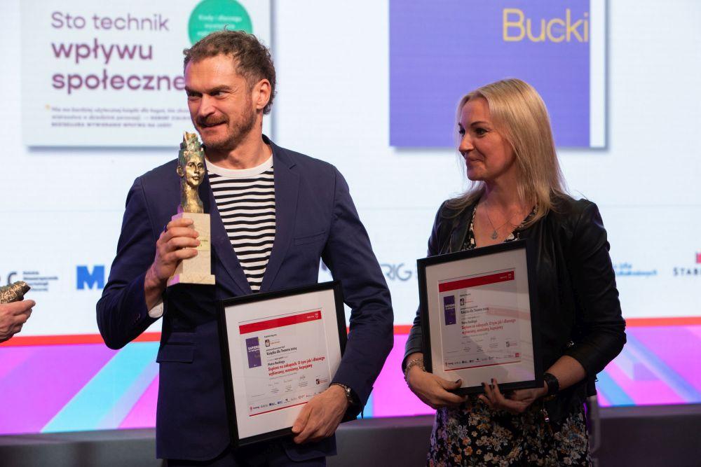 Piotr Bucki ze statuetką i dyplomem