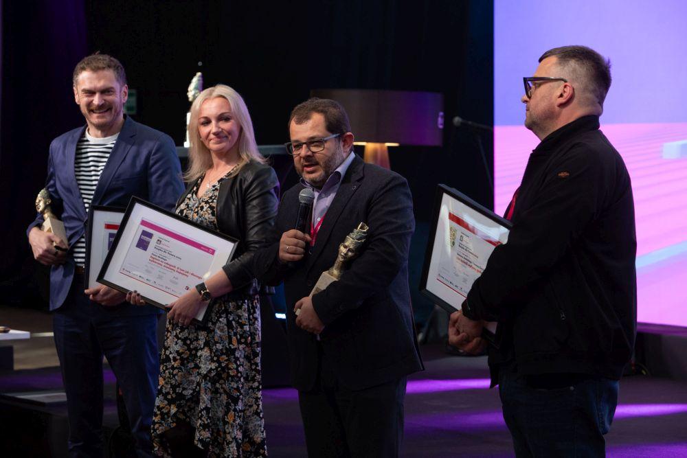 Cztery osoby z dyplomami i statuetkami, w tym Piotr Bucki i profesor Tomasz Grzyb